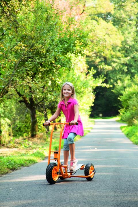 Toptrike Step'n Roll klein: Kind fährt auf Dreirad auf einem Weg. KiTa-Spielewelt