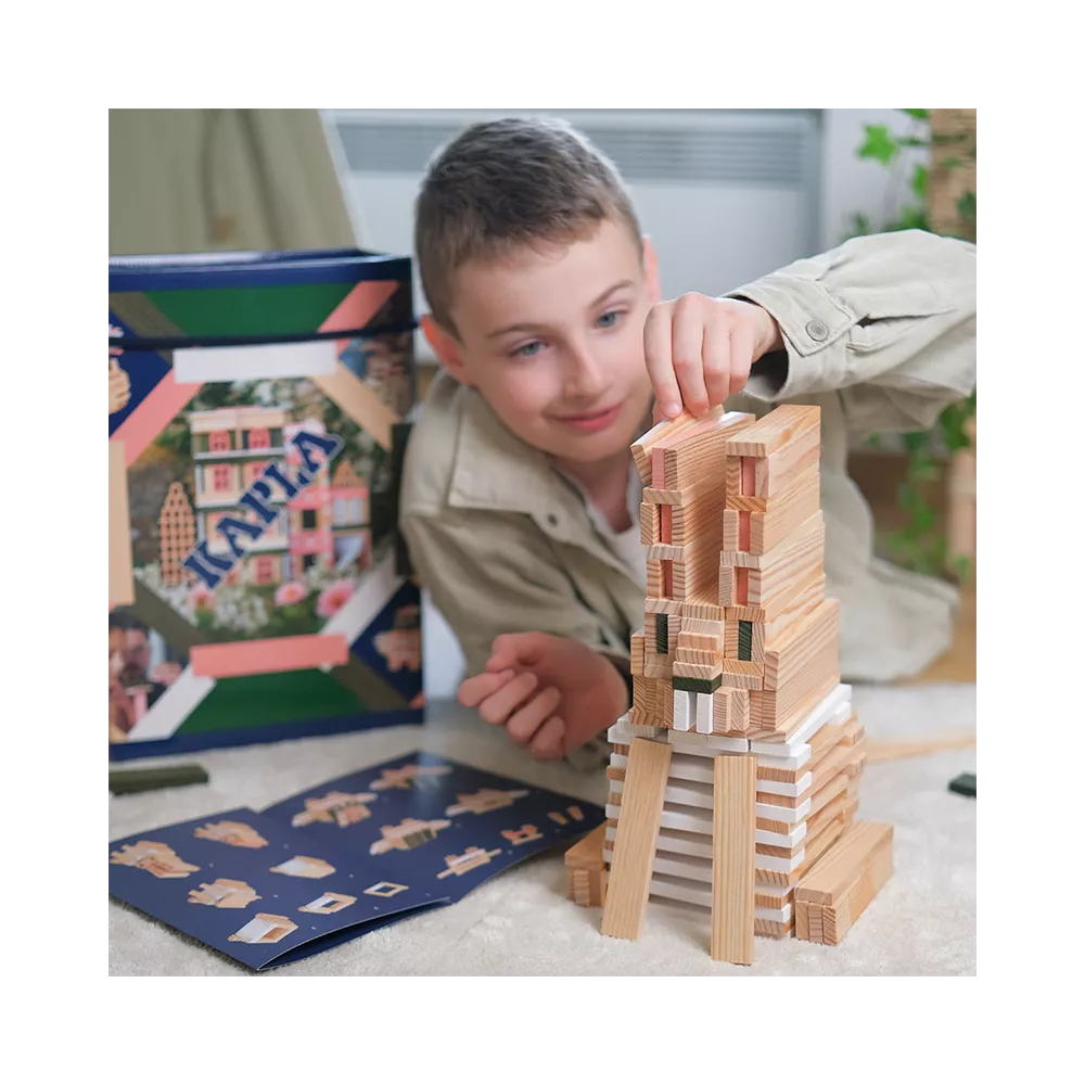 Kapla 200er Box rosa: Kind baut einen hohen Turm mit Holzbausteinen. KiTa-Spielewelt