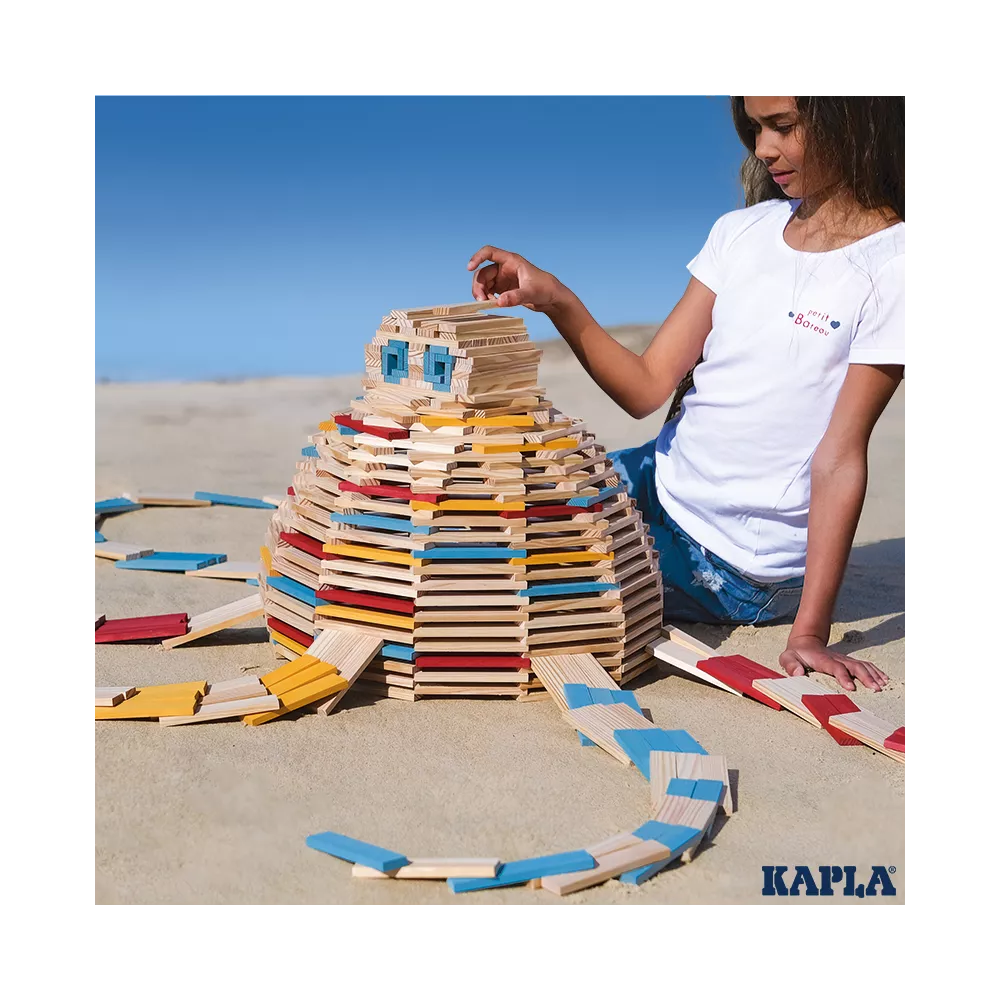 KAPLA® Bausteine Sommer ,Kind baut eine Kuppel aus Kapla-Bausteinen am Strand