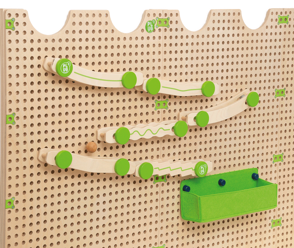 PLUG IT Kugelbahn-Set: Nahaufnahme der Holzkugelbahn mit grünen Elementen an der Lochwand in einer Kita